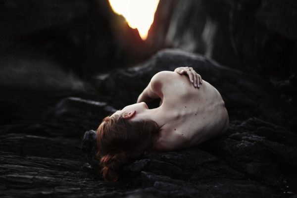 Девушка лежит на камнях