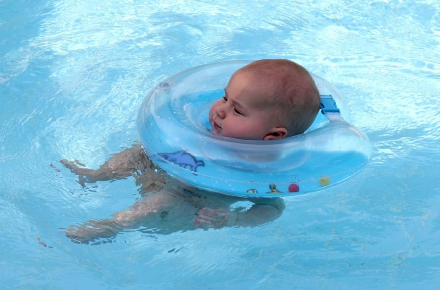 Ребенок купается с кругом на шее